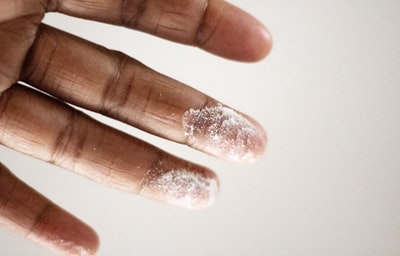 人的手指沾上白色粉末的特写照片